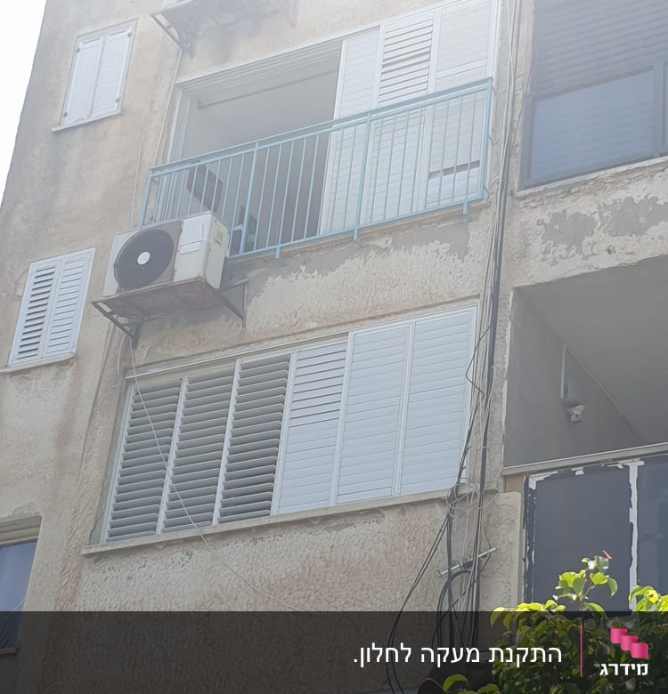 מרפסת עם מעקה מתכת כחול ומזגנים מותקנים